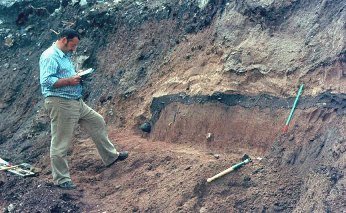 Notgrabung 1973 auf dem Burgplateau: In der Baugrube fr einen Erweiterungsbau des St. Josefheimes ist deutlich eine dunkle Planierungsschicht zu sehen, darin links das Fragment eines Topfes. Im Bild Gnther Hain.